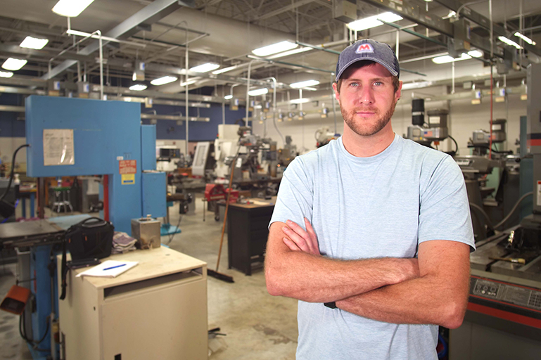 Student standing in machine shop