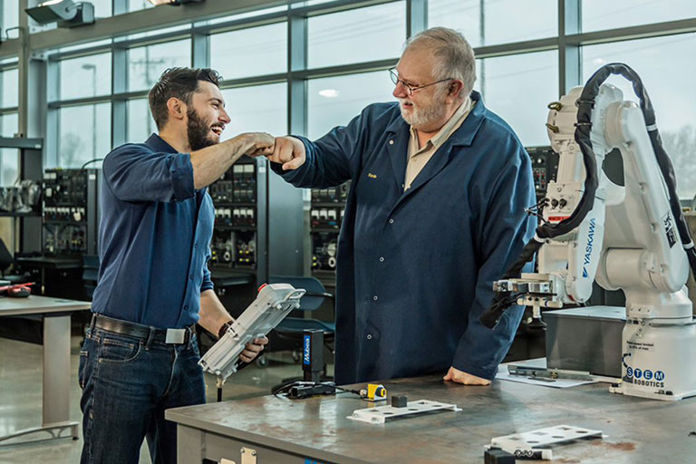 Instructor and Student. Robotics. Fist Bump.