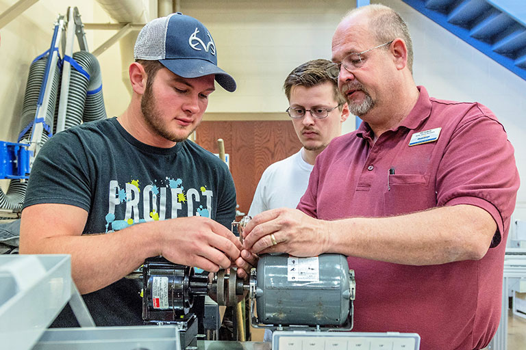 Students working on electrical motor. 